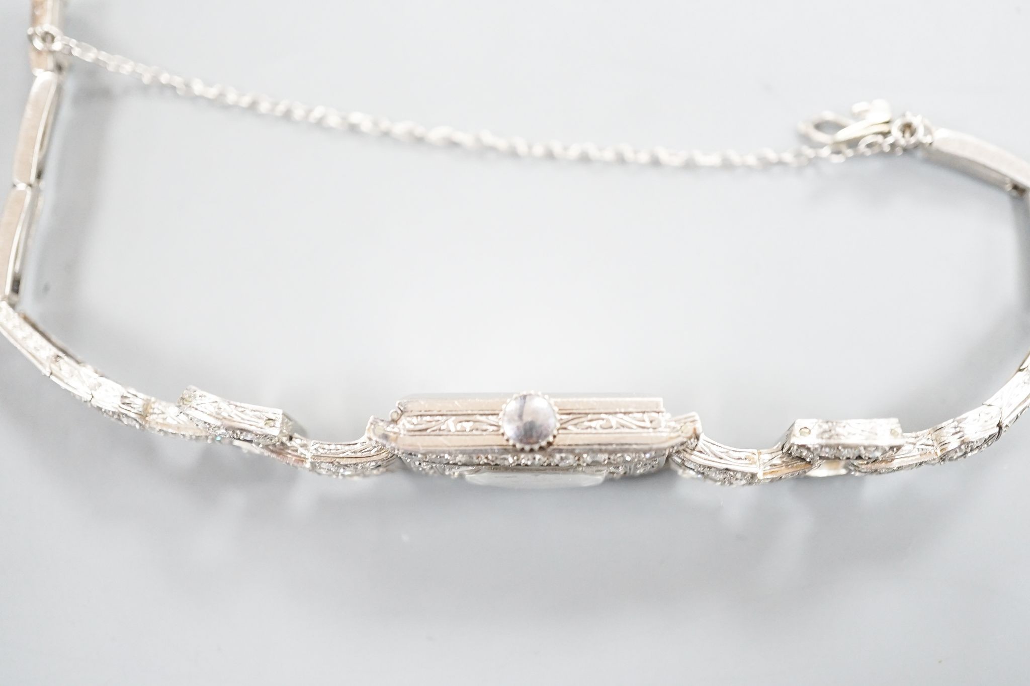 A lady's white metal (stamped platinum) and diamond set cocktail watch, the bracelet with diamond set shoulders, approx. 16cm, gross weight 23.8 grams.